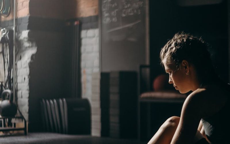 A man in athletic wear preparing for an exercise in a calm, focused environment.