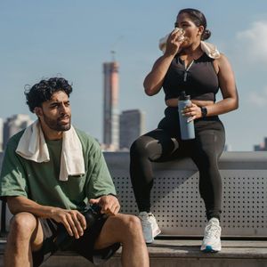 Water bottle and a towel resting on a bench.